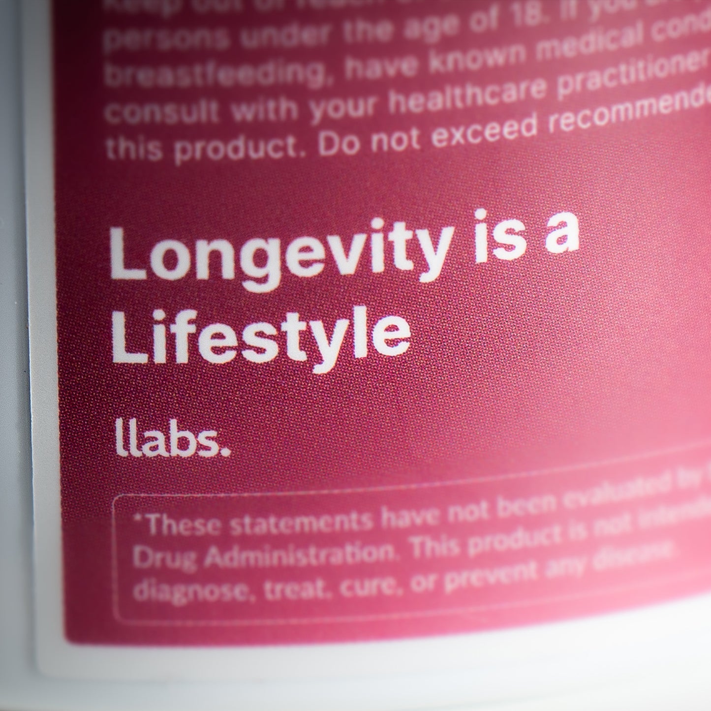 Close-up of a llabs. Fisetin Capsules label with the text "longevity is a lifestyle" on a red background, with additional warning and informational text about llabs. Fisetin capsules below.
